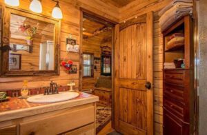 a bathroom with a wood door and a mirror