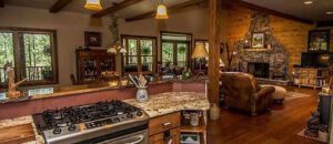 Interior of a kitchen featuring stove, oven, and fireplace.